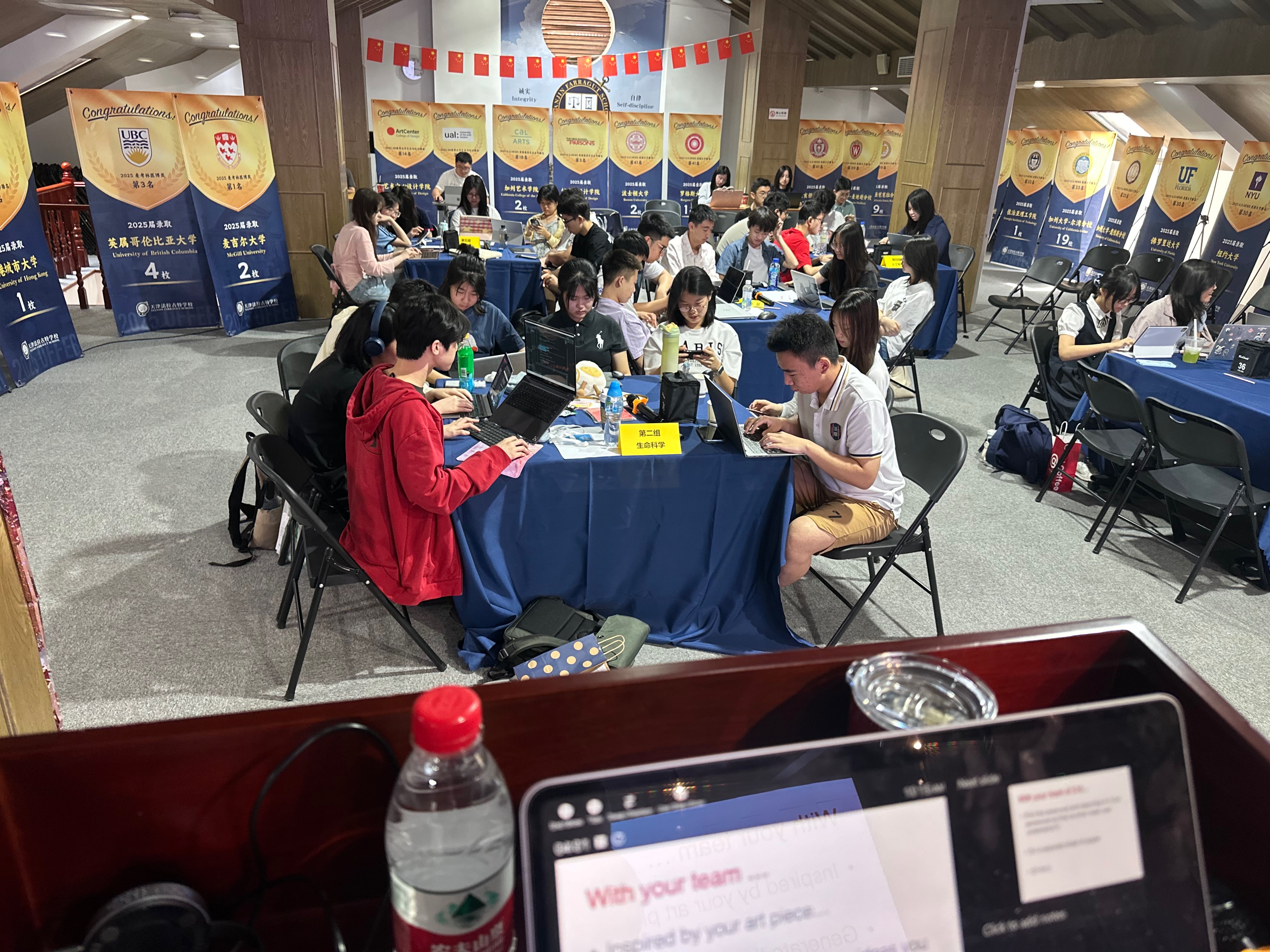 High school students at the CFCC Tianjin Summer Camp working at conference tables on laptops, with an iPad in the foreground showing the Art Thinking exercise prompt: 'With your team... Inspired by your art piece'