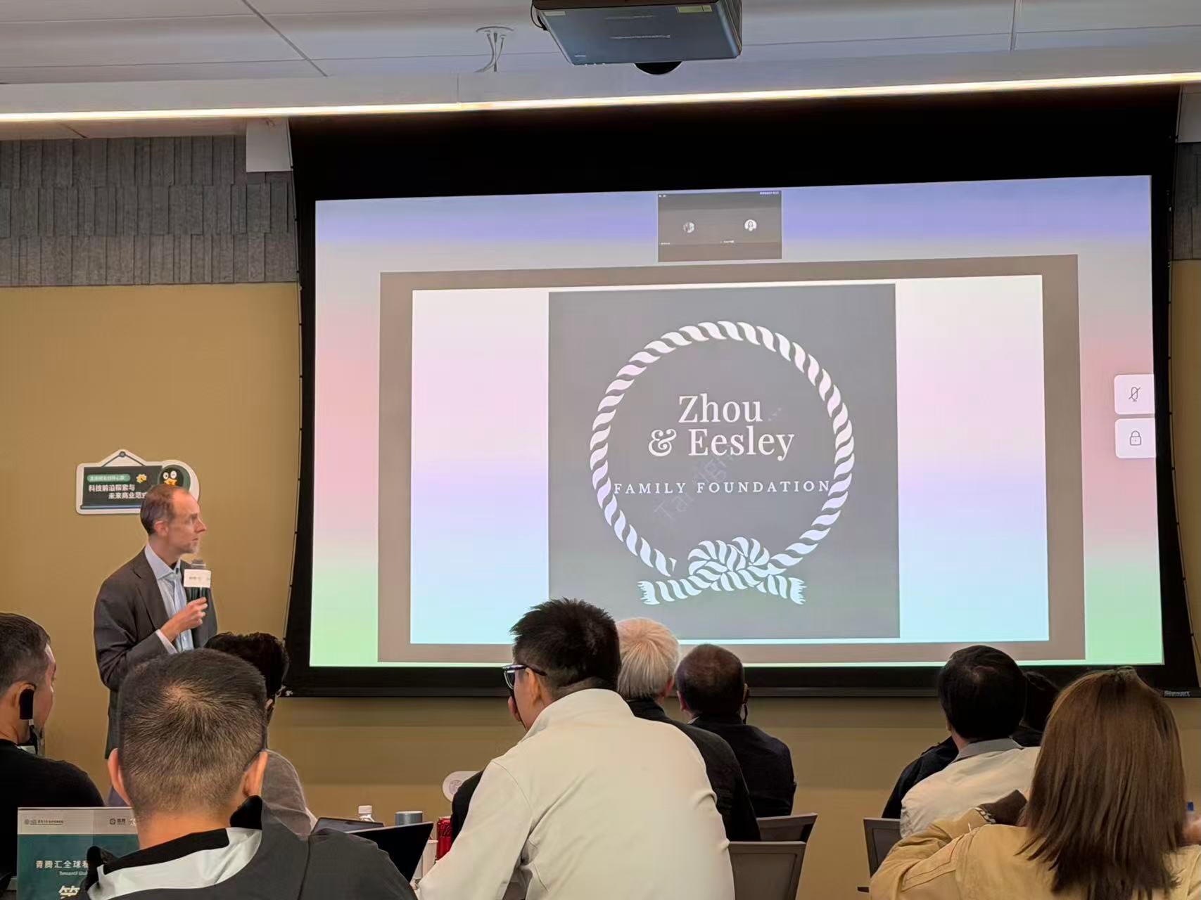Chuck Eesley presenting to the Silicon Valley Innovation Academy executive cohort at Tencent's Palo Alto office, with the Zhou & Eesley Family Foundation logo visible on the projection screen behind him