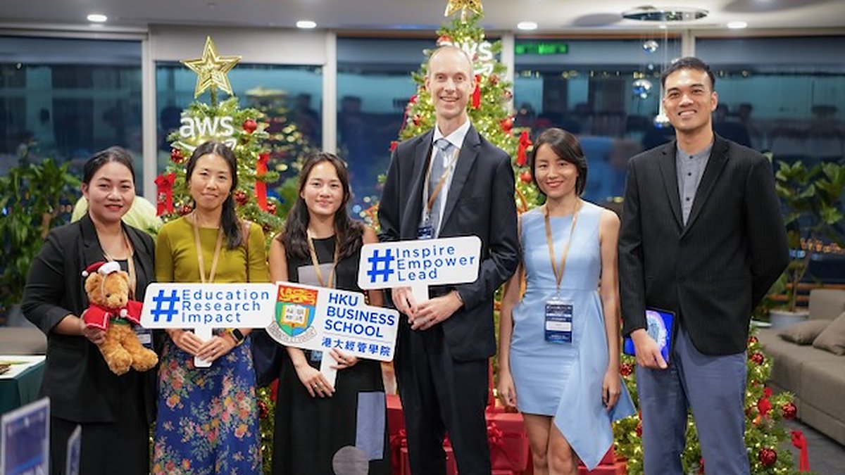 The Foundation team with HKU Business School and AWS Vietnam workshop partners — ‘Education Research Impact’ and ‘Inspire Empower Lead’ signs visible.
